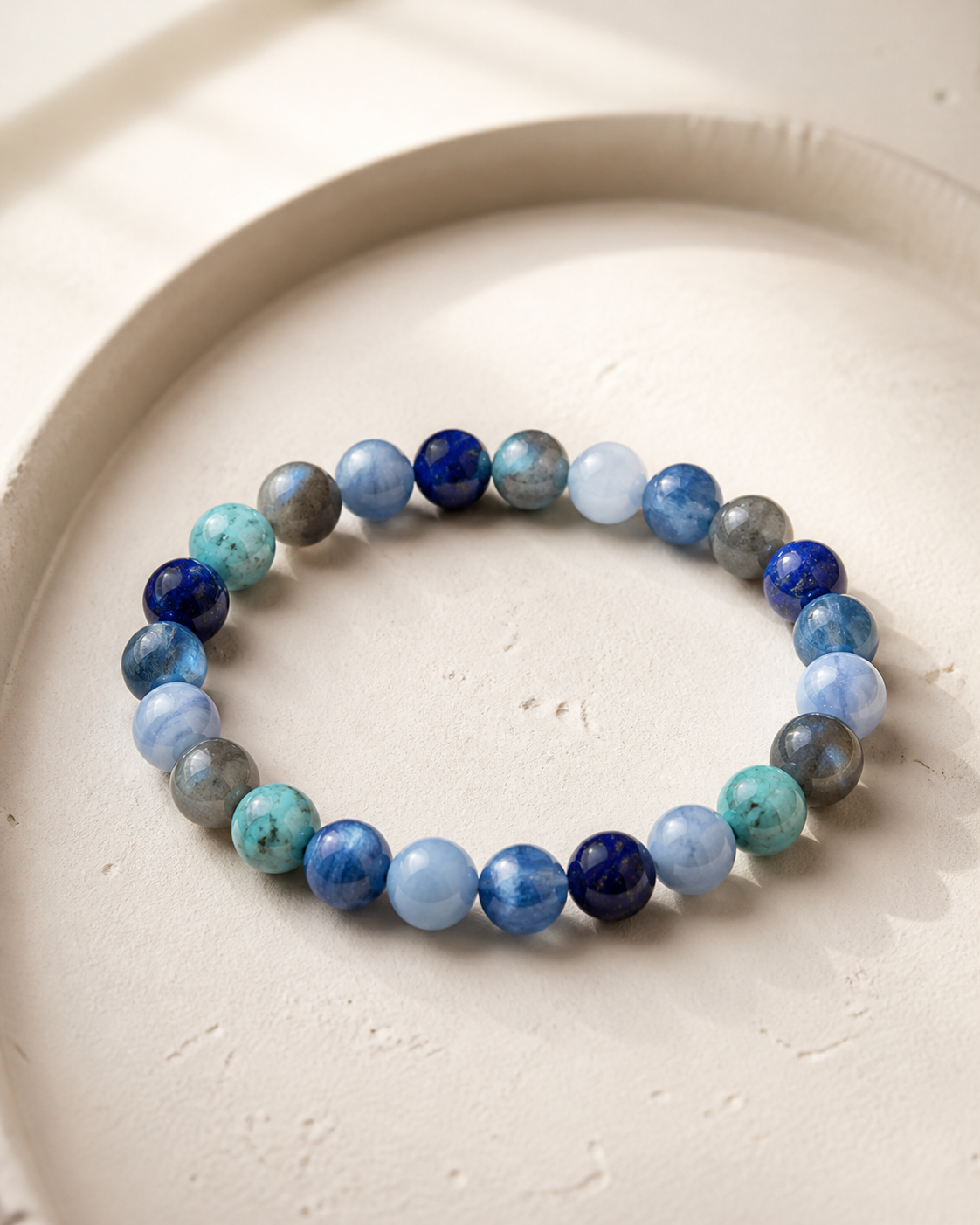 CCustom blue crystal bead bracelet arranged on an ivory tray